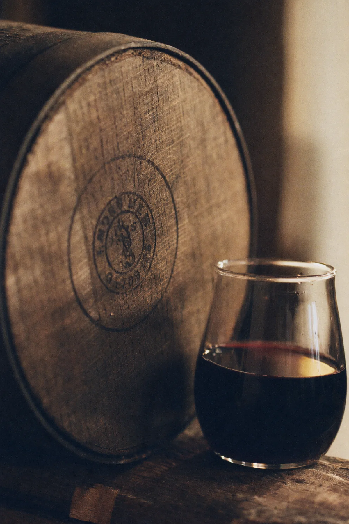 The end-grain of a French oak barrel stave beside a wine thief sample of marselan