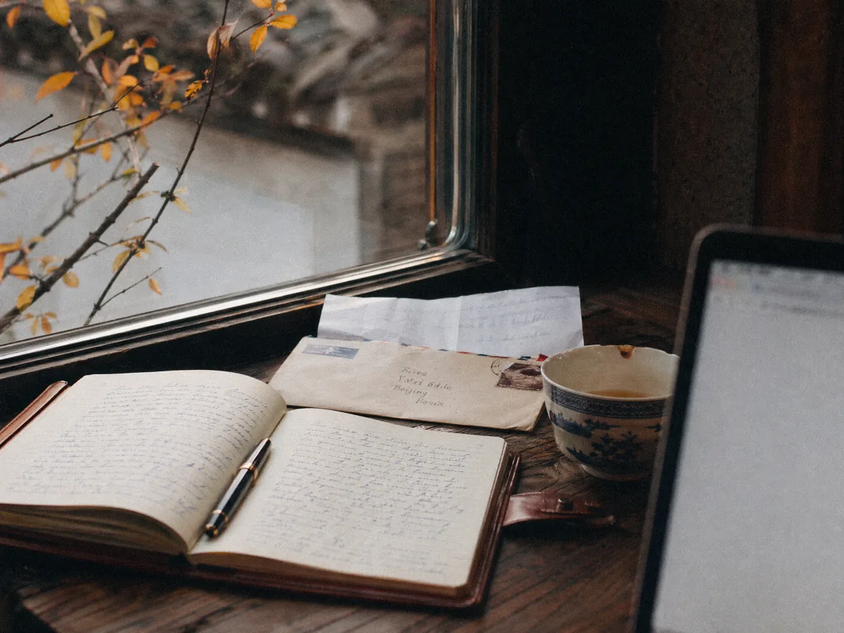 An open leather-bound notebook and an unanswered customer letter on a windowsill