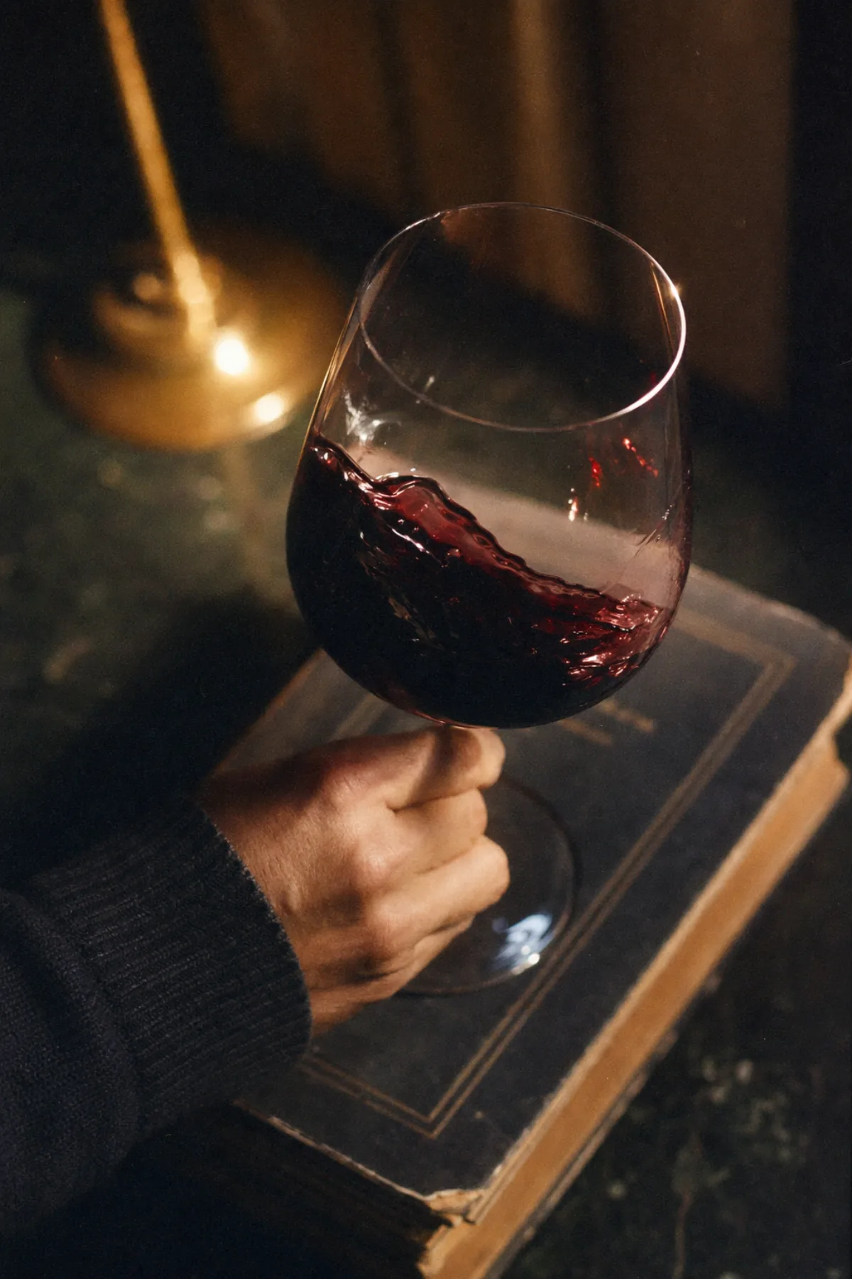 一只水晶杯中摇晃的赤霞珠，托在一本旧书之上